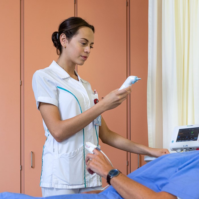 Verpleegkundige meet bloeddruk bij een patiënt op de verpleegafdeling. 