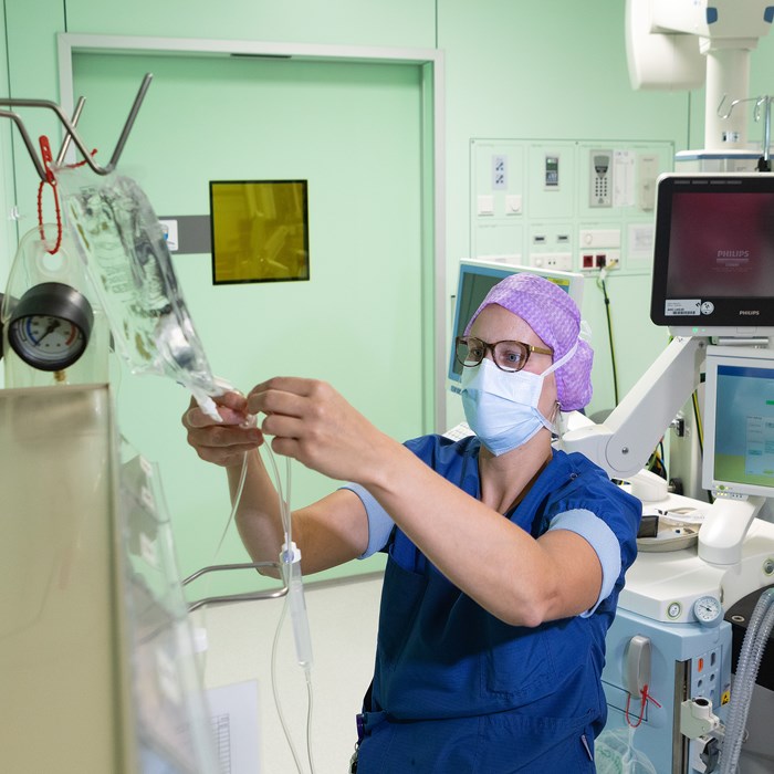 Anesthesiemedewerker controleert infuus in de operatiekamer. 